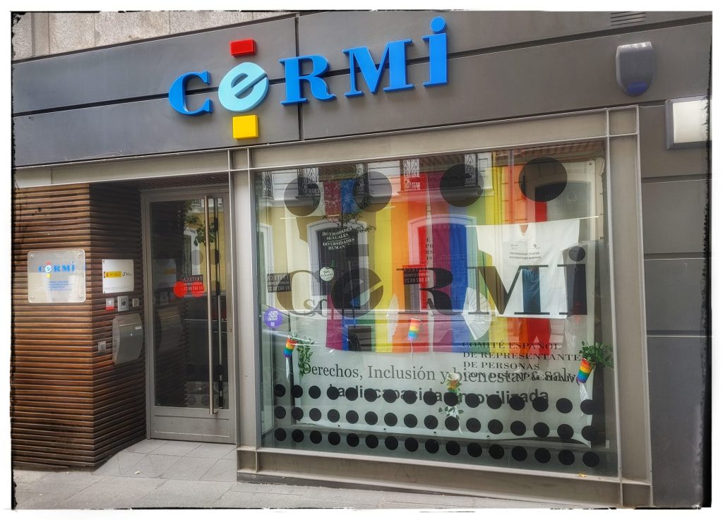 Escaparate de la entrada del CERMI estatal con bandera LGTBI+